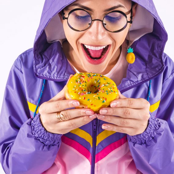 boy in purple jacket eating a donut
